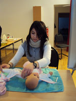 Bild: ein Mädchen windelt ihre Dummypuppe