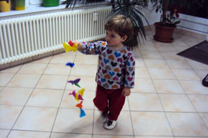 Bild: kleines Kind läuft mit eine Drachenschwanz durch das Zimmer