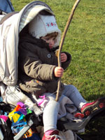 Bild: Kind in einem Kindergarten sitzend hält einen Stock mit einem Drachen darn