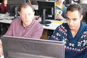 Bild: zwei Männer blicken auf einen Desktop-Monitor